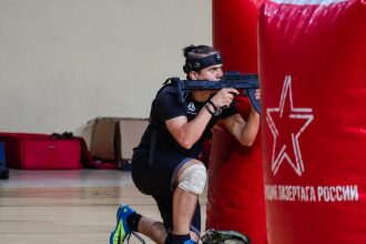 Боец LASERWAR держит оружие, готовясь к виртуальному бою.